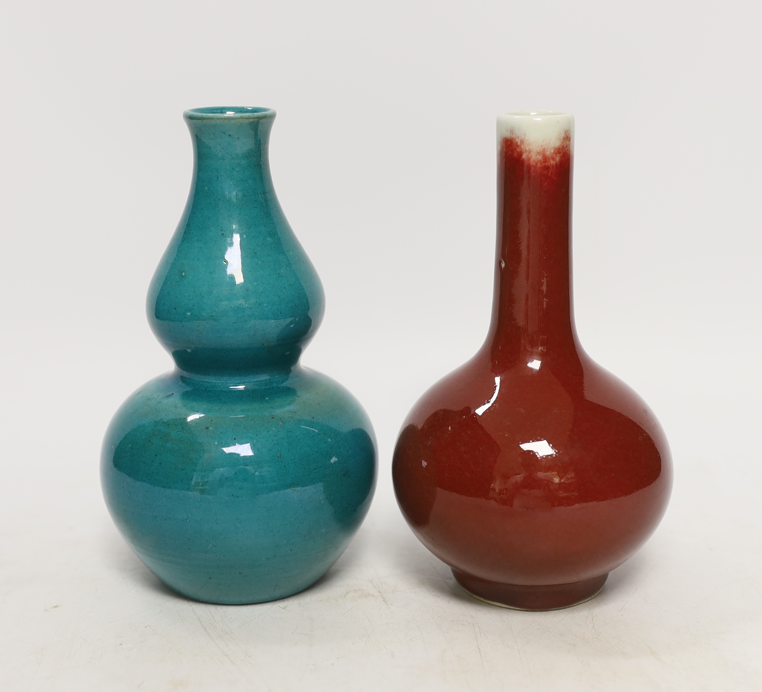 A Chinese monochrome gourd vase together with a similar sang de boeuf bottle vase, tallest 16cm